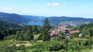 a house on a hill with a view of a lake at Les Jonquilles: gîte 8/10 pers. avec vue imprenable! in Gérardmer