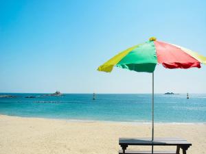 固城Seaside Minbak的海滩上带遮阳伞的长凳