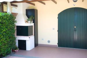 two green doors on the side of a building at Villaggio Teodorico in Punta Marina
