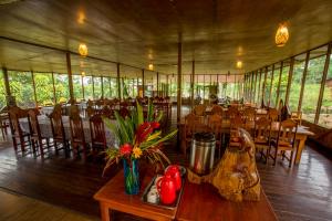 uma sala de jantar com mesas e cadeiras numa tenda em Monte Amazonico Lodge em Tambopata