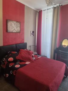 a red bedroom with a bed with a red blanket at Hôtel des allées in Marseille