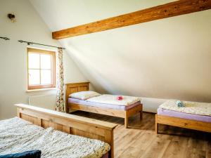 a attic room with two beds and a window at Statek Humenec - Klid u lesů, Česko in Valašská Bystřice