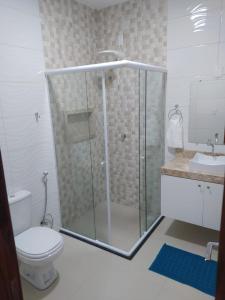 uma casa de banho com um chuveiro, um WC e um lavatório. em Pousada BarbacoaR na Parnaíba