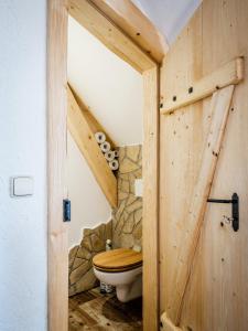 a bathroom with a wooden door with a toilet at Statek Humenec - Klid u lesů, Česko in Valašská Bystřice