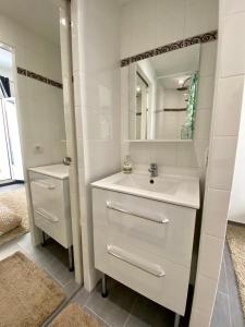 een witte badkamer met een wastafel en een spiegel bij Central and Convenient Studio in Monaco in Monte Carlo