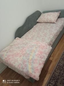 un letto con una coperta rosa e un cuscino di Mercy Deluxapartment a Visoko