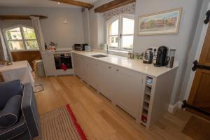 a kitchen with white cabinets and a counter top at The Barn, Stourton in Sutton under Brailes