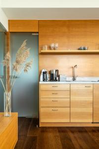 a kitchen with wooden cabinets and a sink at Visit Nida Apartments in Nida