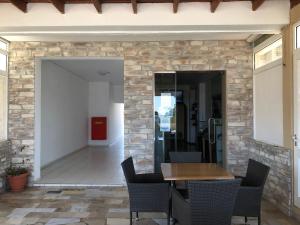 a dining room with a stone wall and a table and chairs at Anthoulis Studios in Kefalos