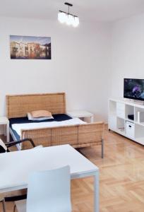 sala de estar con cama y TV en apartament Hallera Square Warsaw 27m2, en Varsovia