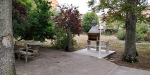 una parrilla sentada junto a una mesa y un árbol en Villa Merenciana en Agoncillo