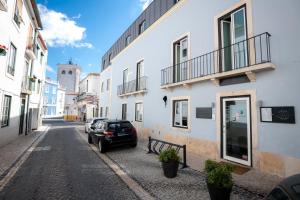 um carro estacionado numa rua ao lado de um edifício em Villa Graça -Hostels and Apartments em Santarém