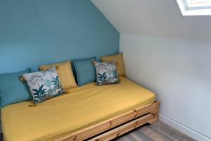 a small bed in a corner of a room at LA PETITE MAISON PRÈS DE LA MER in Fécamp