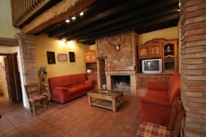 salon z czerwonymi kanapami i kominkiem w obiekcie Casa Rural Finca El Tornero w mieście Aracena