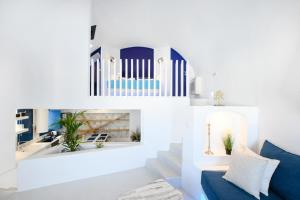 sala de estar con paredes blancas y sofá azul en Blue White Residence, en Monolithos