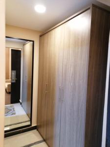 a large wooden cabinet in a room with a mirror at Al Shaiki Hotel in Al Jubail