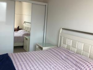 1 dormitorio con cama y mesa de cristal en Ap. Resort Recreio dos Bandeirantes, en Río de Janeiro