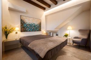 ein Schlafzimmer mit einem Bett, einem Stuhl und einem Gemälde in der Unterkunft Zu Bastianu House in Alcamo