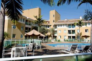 un resort con piscina attrezzata con sedie e ombrelloni di The Sun Full Condominiun a Brasilia