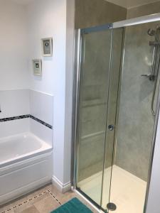 um chuveiro na casa de banho com uma banheira e um lavatório em Family Run Farm B&B em Gooseham