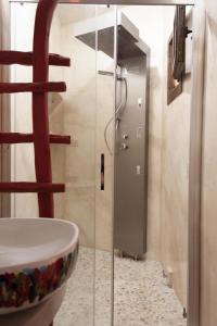 a bathroom with a shower stall and a toilet at Hotel Anticos Palathos in Orosei