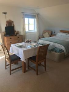 a room with a table and two chairs and a bed at Family Run Farm B&B in Gooseham