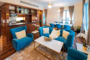 a living room with blue chairs and a table at FIRST CLASS 2BR with full BURJ KHALIFA and FOUNTAIN VIEW in Dubai