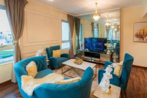 ein Wohnzimmer mit blauen Sofas und einem TV in der Unterkunft FIRST CLASS 2BR with full BURJ KHALIFA and FOUNTAIN VIEW in Dubai