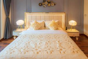 a bedroom with a large white bed with two lamps at FIRST CLASS 2BR with full BURJ KHALIFA and FOUNTAIN VIEW in Dubai +30 photos