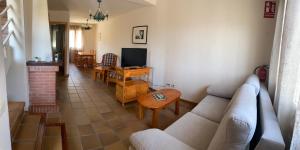 ein Wohnzimmer mit einem Sofa, einem Tisch und einem TV in der Unterkunft Sierra Norte in Canencia