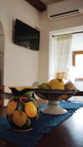 een tafel met twee vazen gevuld met fruit erop bij Mariuccia House in Amalfi +10 foto's