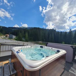 a hot tub on a balcony with a view at Tri sestry in Demanovska Dolina