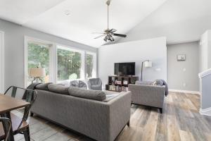 een woonkamer met een bank en een tafel bij Bissell Creek Woodside Cottage in Williamsburg