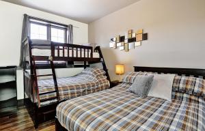 een slaapkamer met 2 stapelbedden en een bed bij Chalet 15 Chemin Blanc by Les Chalets Alpins in Stoneham