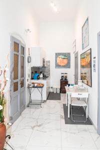uma cozinha com paredes brancas e piso em azulejo branco em "DueEmme Lodge" , a pochi passi dal porto em Livorno