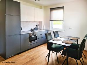 a kitchen with a table and chairs in a kitchen at Friendship Suite in Mörbisch am See