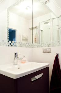 La salle de bains est pourvue d'un lavabo et d'un miroir. dans l'établissement Sunny Stay Apartment, à Świnoujście
