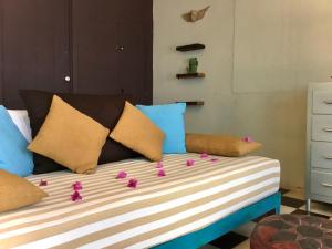 a bed with colorful pillows and flowers on it at Unique Studio Beach RG4 in Puerto Vallarta