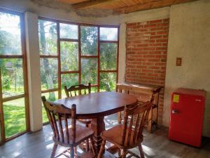 a dining room with a table and chairs and a red refrigerator at Hotel Rincon Del Real in Mineral del Monte