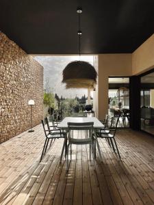 a dining room with a table and chairs on a wooden floor at Les Loges en Provence - Villa Contemporelle in Pujaut