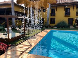 a swimming pool with a fountain in front of a house at Maria Barbosa Tiradentes Pousada e Spa in Tiradentes +29 photos