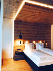 two beds in a bedroom with a wooden wall at Fritz Lauterbad in Freudenstadt