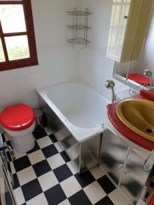a bathroom with a toilet and a tub and a sink at Gîtes Les Perouilles - La loge climatisée de Naïda in Puymiclan
