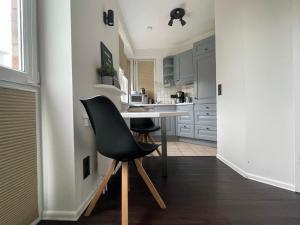 a kitchen with a table and a black chair at Hafenbude Husum in Husum