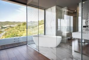 a bathroom with a tub and two sinks and a window at Yacht Hotel in Vlorë
