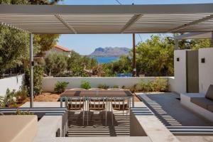 a patio with a table and chairs under a canopy at Chania Living Stories Villa with Piano in Chania