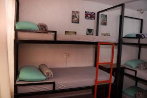 a room with three bunk beds with a ladder at Cacau Hostel in Goiânia