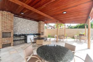 un patio con mesa, sillas y chimenea en Aloha Residence, en Porto de Galinhas