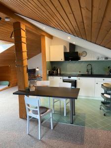 a kitchen with a wooden ceiling and a table and chairs at Roof Heaven Ferienwohnung in Blaichach