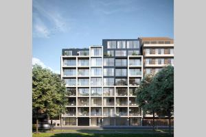 un gran edificio de apartamentos con árboles delante de él en Schitterend nieuwbouw appartement in Gent, en Gante